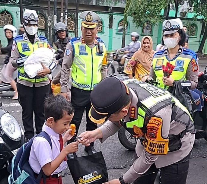 Kapolrestabes Medan Turun Ke Jalan Bagi-Bagi Helm Sambil Sapa Anak Sekolah dan Pantau Arus Lalu Lintas